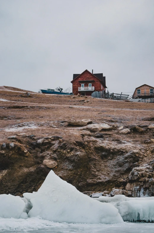 a house on a hill overlooking an icy body of water