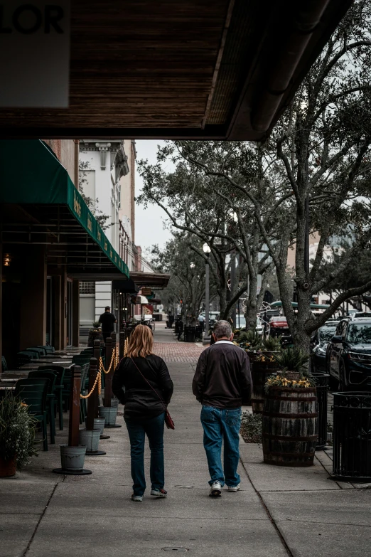 two people walking down a street towards an office