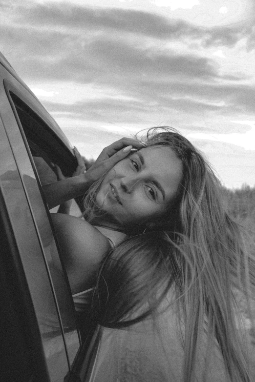 a girl leaning out of a car window