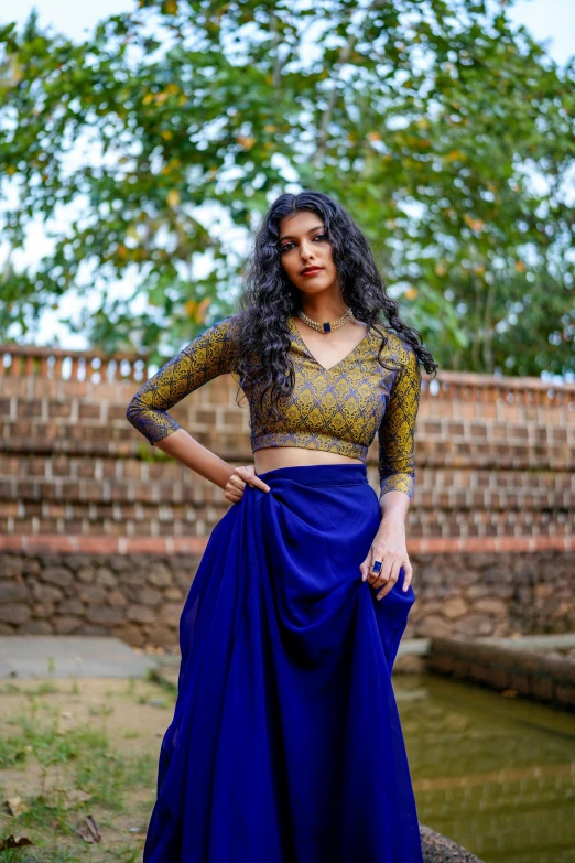 woman posing outdoors in a blue colored saree