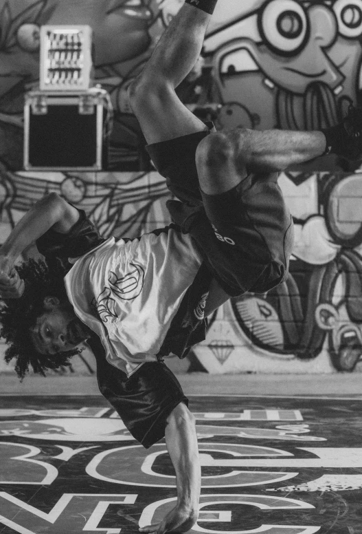 black and white pograph of a person doing a handstand on a basketball court