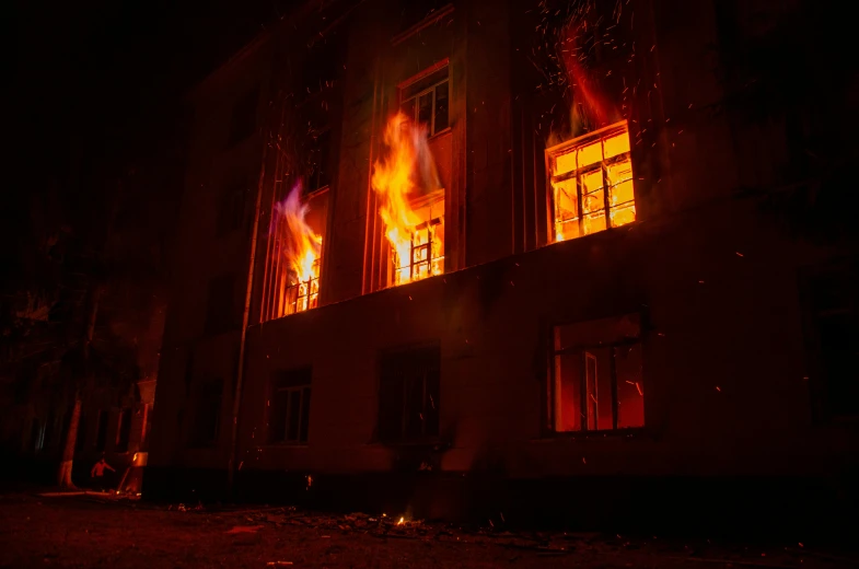 flames are visible from windows in this dark lit building
