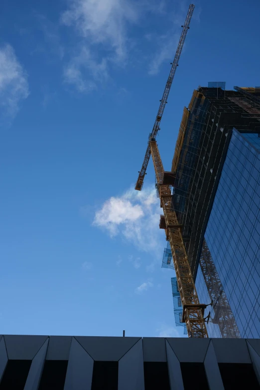 the crane is on top of the building and sky is in the background