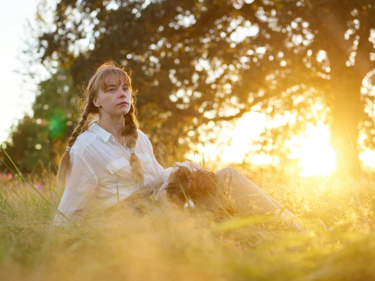 a woman with long hair laying down on the ground