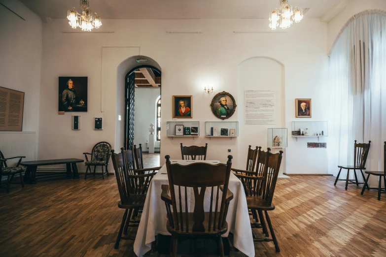 the dining room has a wooden table with two white clothed tables