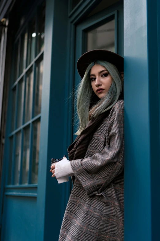 a woman with grey hair is standing on a blue building