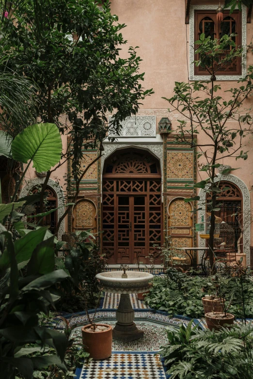 an ornate courtyard with tiled floors and potted trees