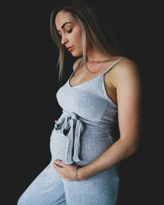 a pregnant woman with her belly on black