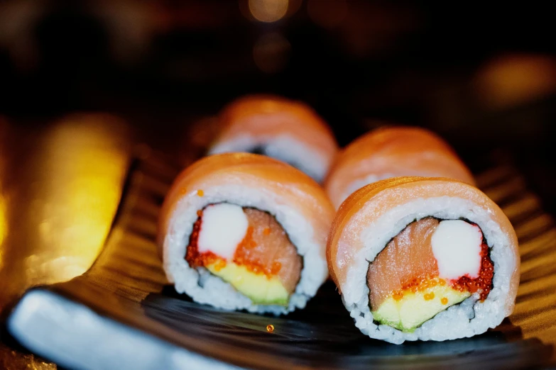 rolls with rainbow sauce and white cheese on a wooden platter