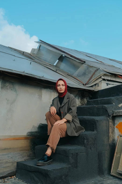 a person sitting on steps and wearing a scarf