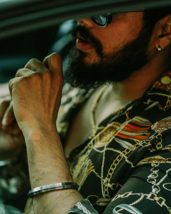 a man in a cowboy hat, wearing a watch, driving