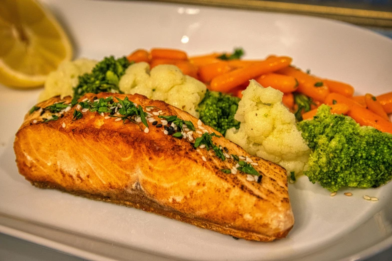 a plate that has some salmon and vegetables on it