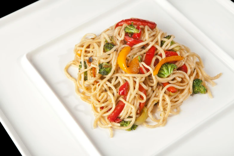 a white plate topped with spaghetti and vegetables