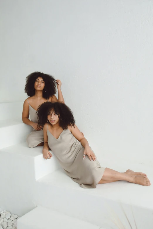 a couple of women sitting on top of a white step