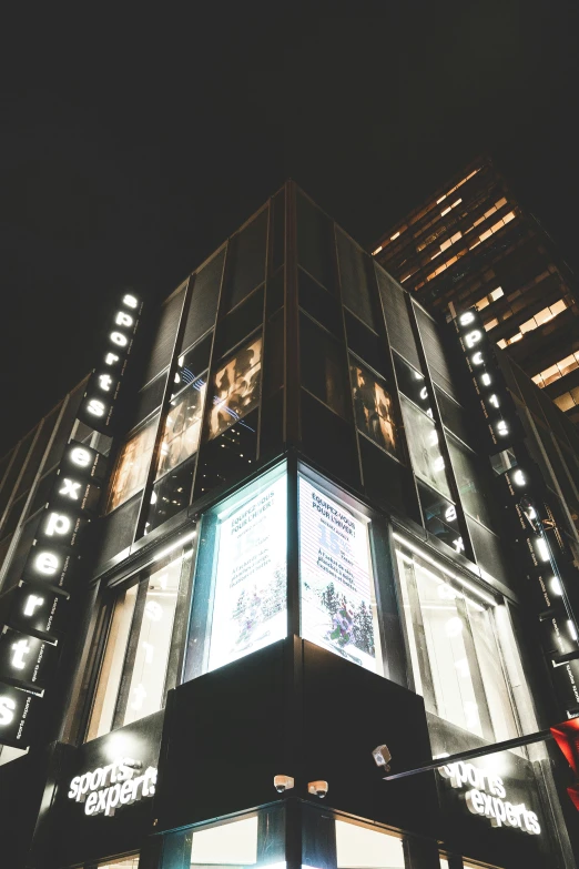 a building with several lit up windows in front of it