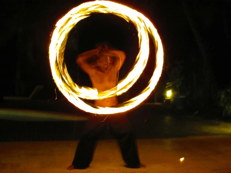 a man spinning fire around in the dark