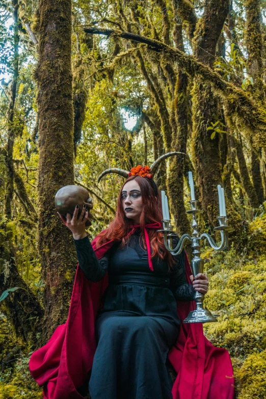 woman in black and red robe holding a doughnut in hand