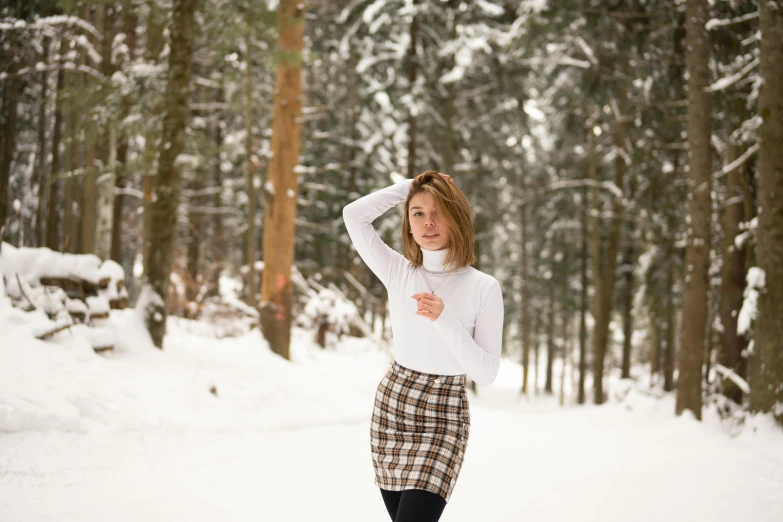 a woman walking through the snow in her skirt