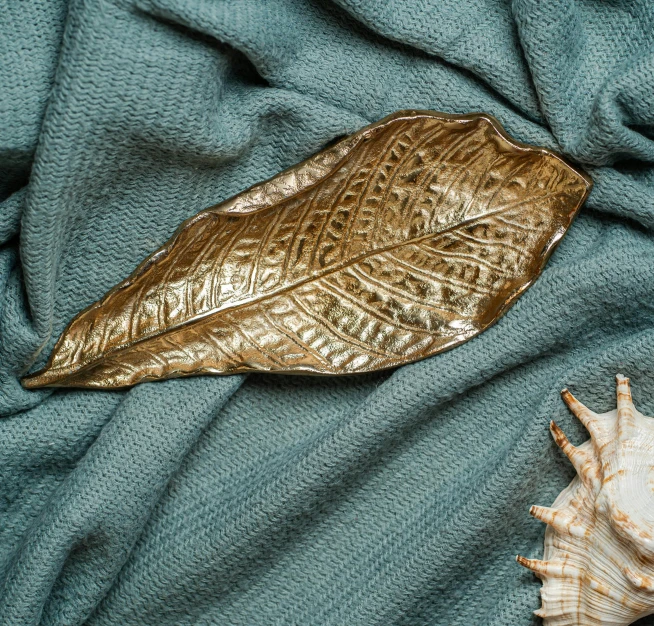 golden leaf laying on top of a blue cloth