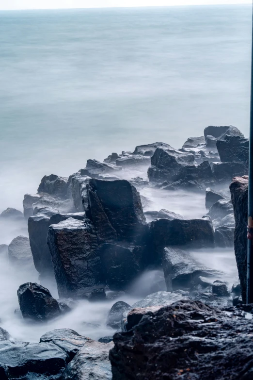 a person with an umbrella looking over the ocean