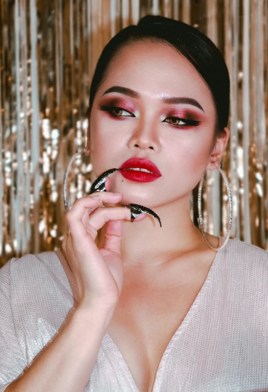 a woman with red lips wearing statement earrings