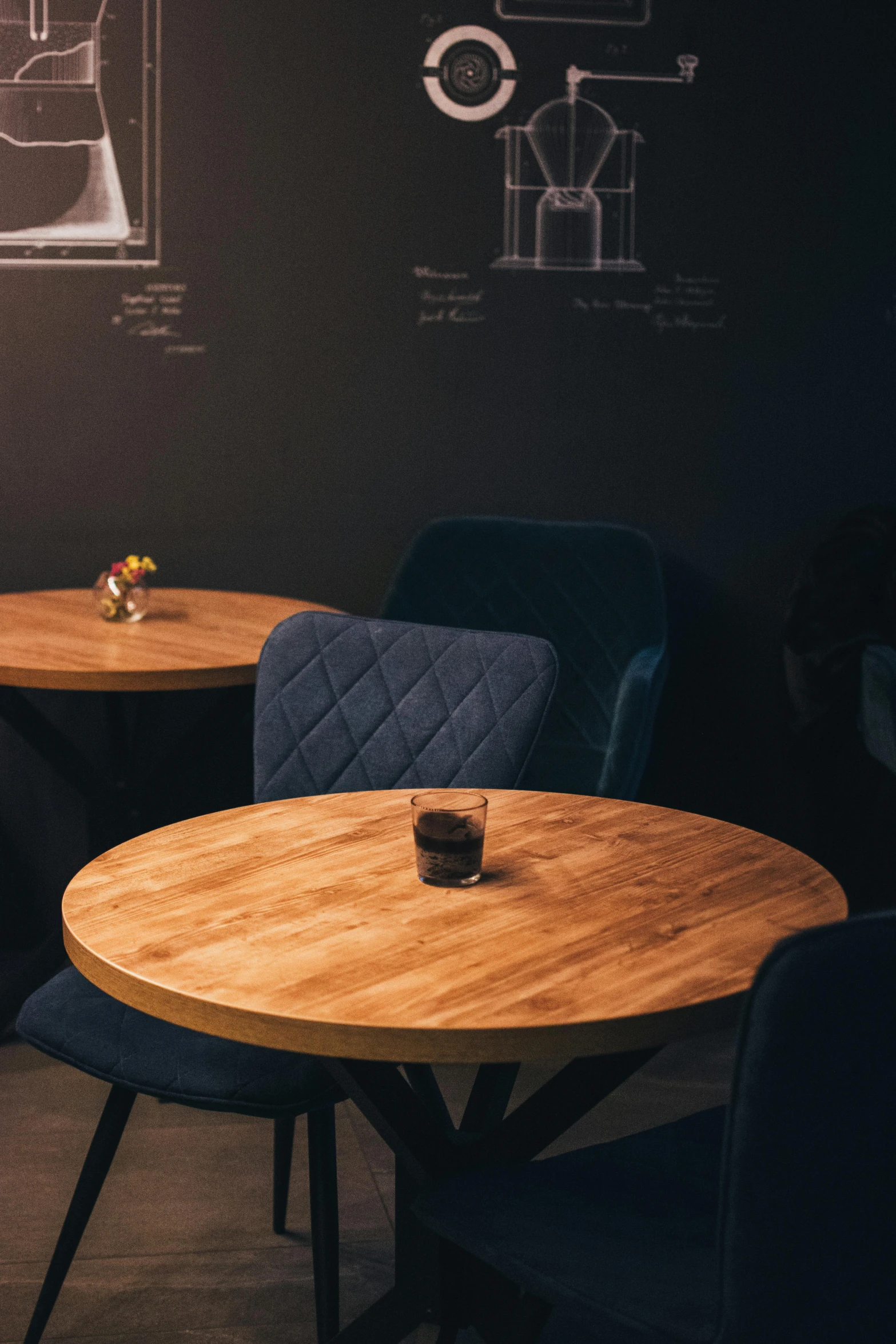 a chair and table in the dining room with drawings on the wall