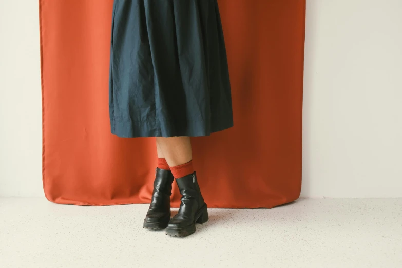 a woman in black dress and black booties with her arms wrapped around the back