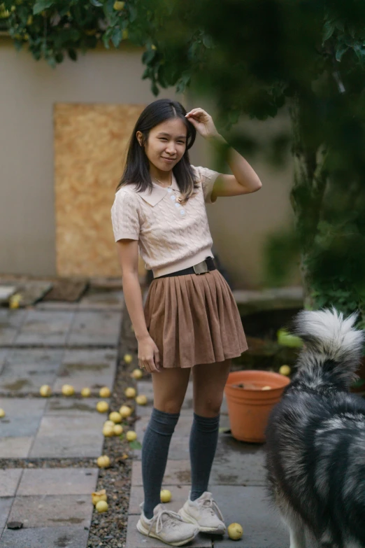 a girl who is wearing a skirt and has apples scattered all over her