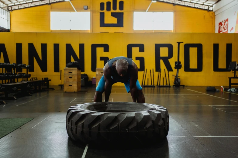 man doing crossfit with tires in indoor gym