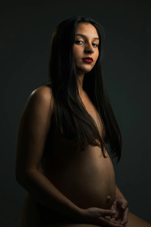 a pregnant woman posing for a portrait with her hands in the belly