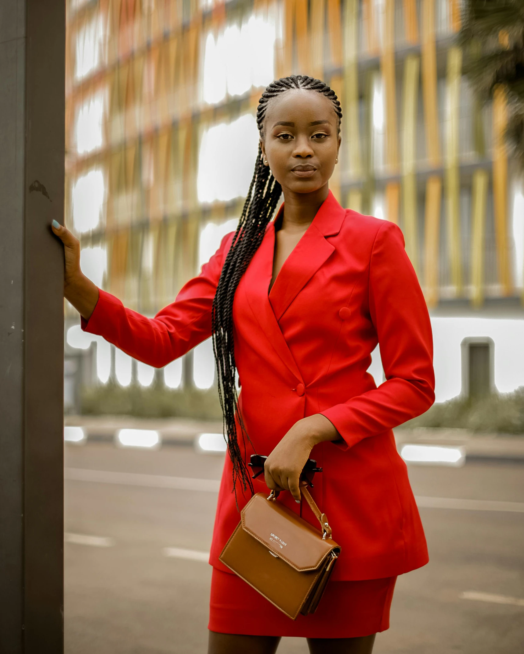 an attractive young woman in red holding a purse