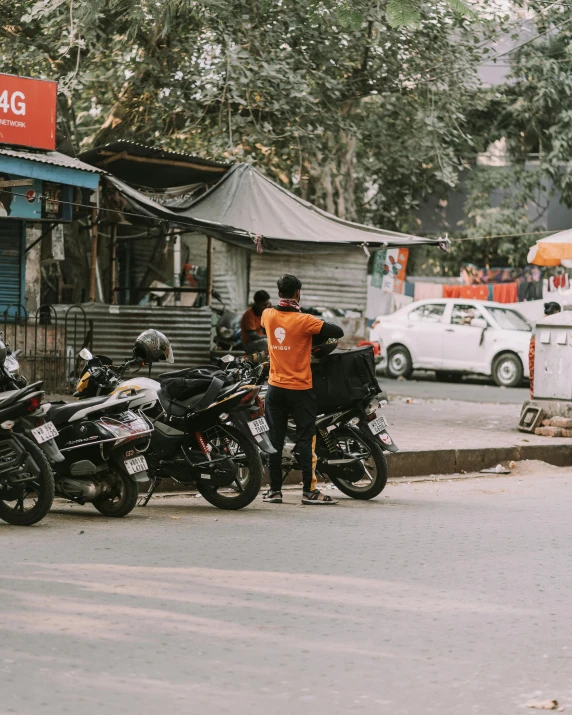 a person is standing next to some parked motor cycles