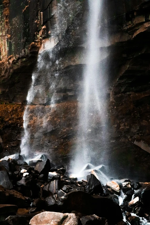 a waterfall that is spraying water onto the rocks