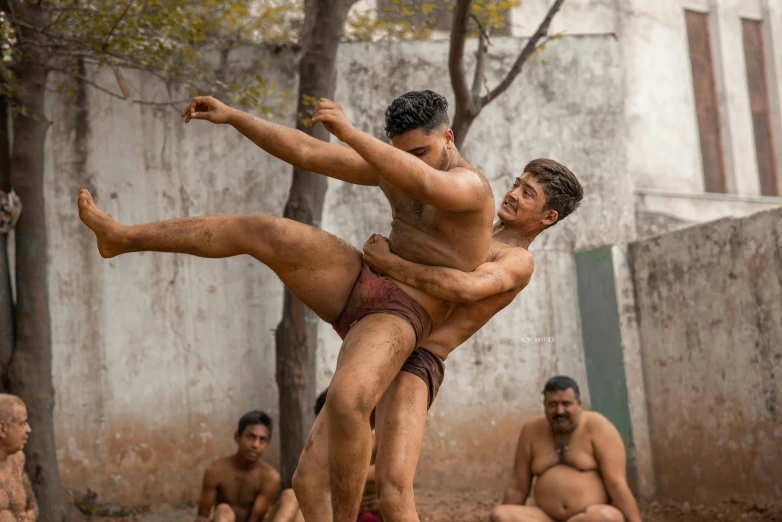 two people kick each other and others look on