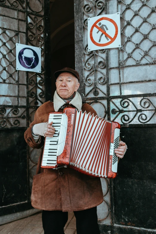 a man is playing an accord piano outside