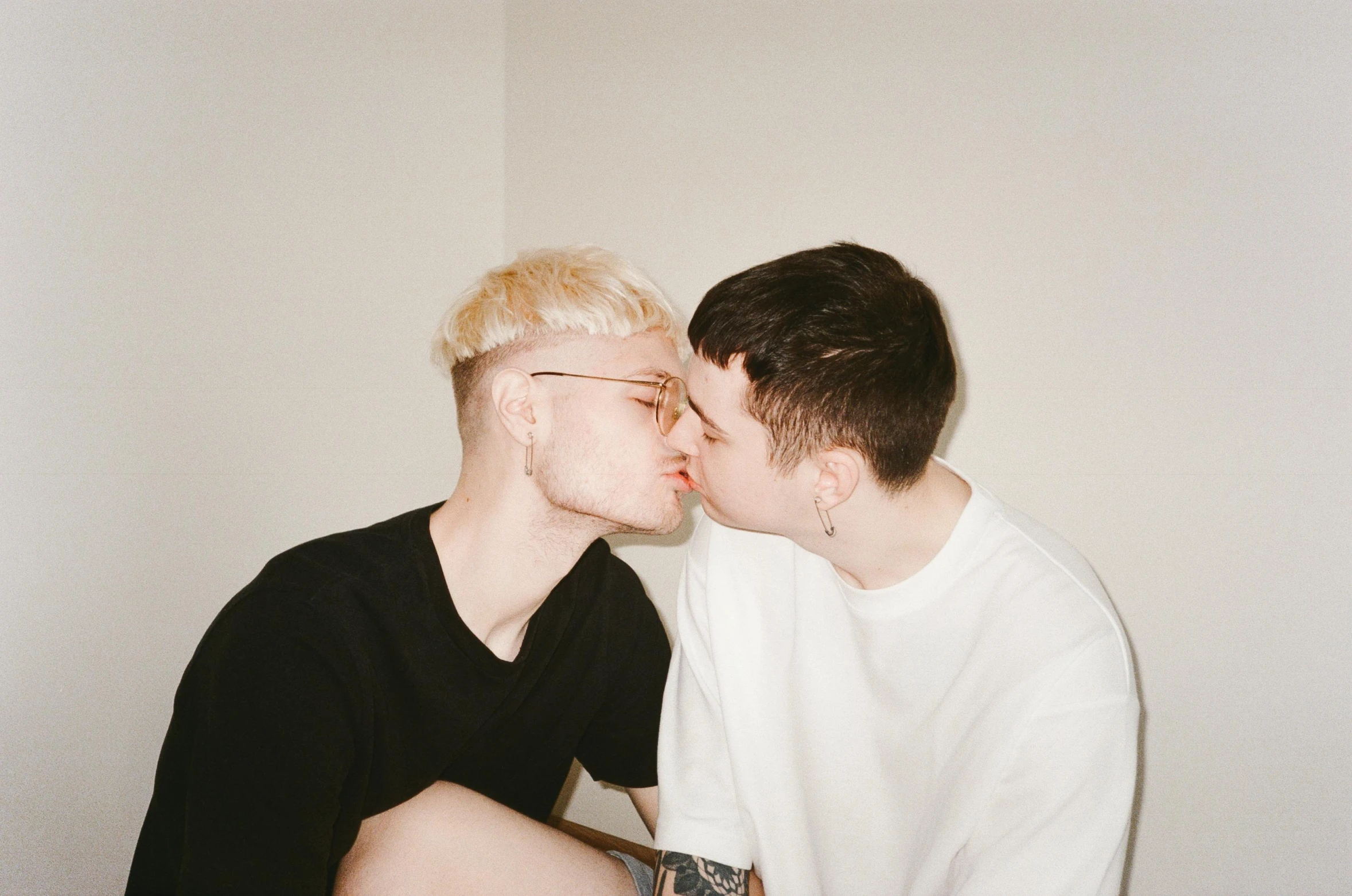 two young people are kissing while wearing white shirts