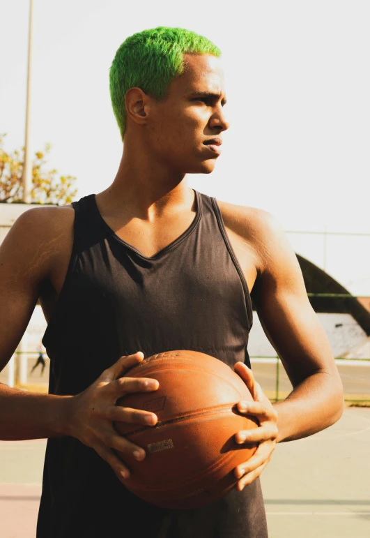 a man with neon green hair holding a basketball