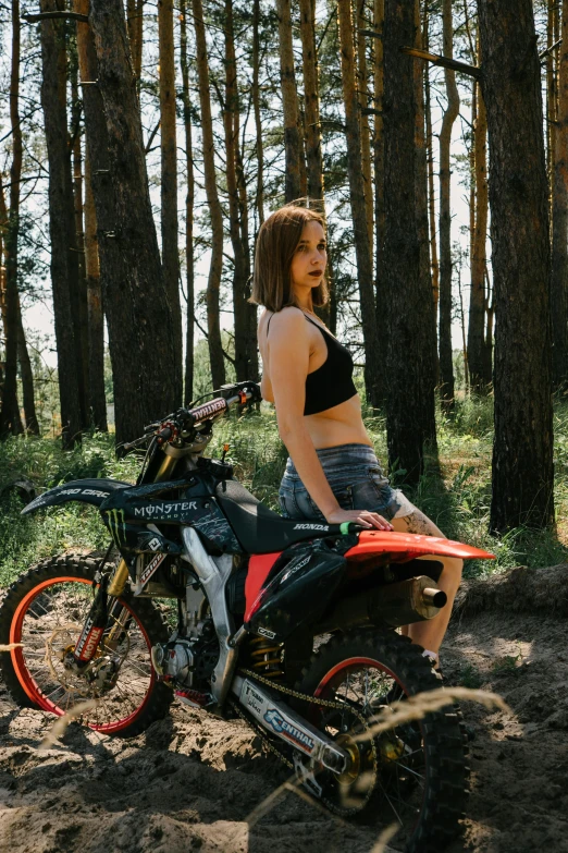 the woman is sitting on her dirt bike