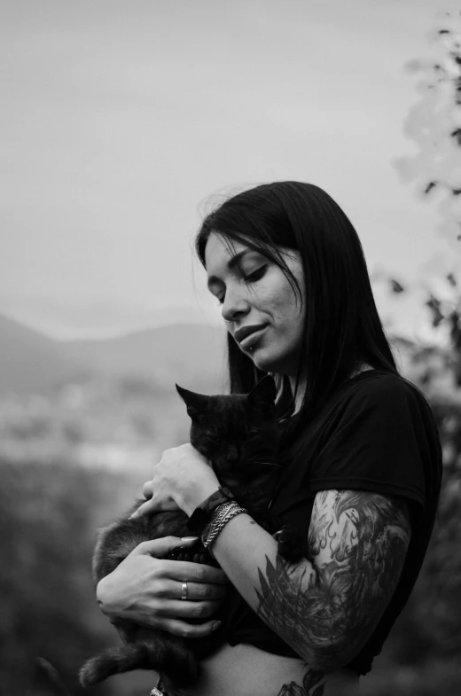 a woman holding a cat looking off into the distance