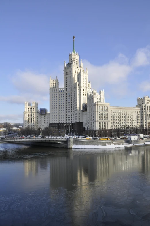 a large building with two floors on the top of it next to a river