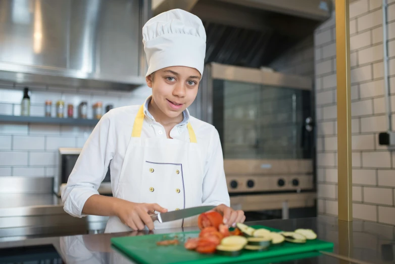 a young chef is  up vegetables in the kitchen