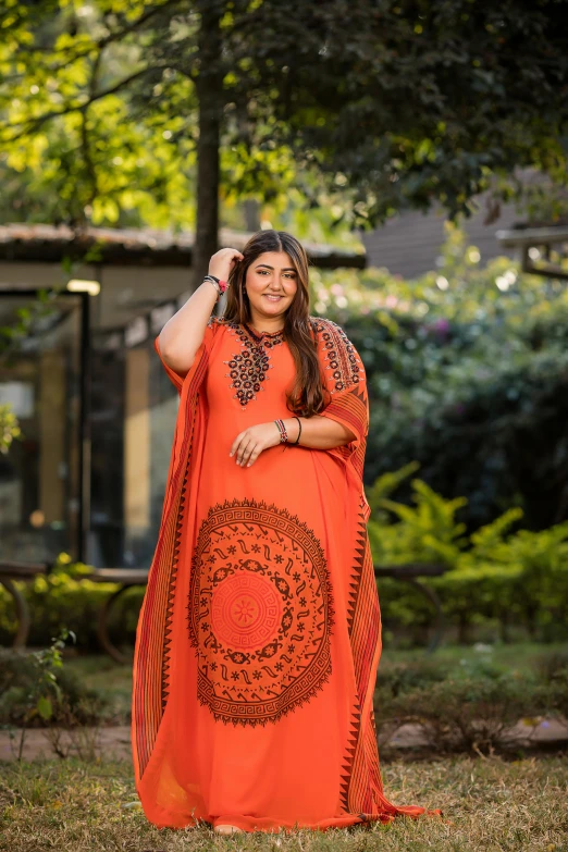 an attractive woman in an orange outfit posing