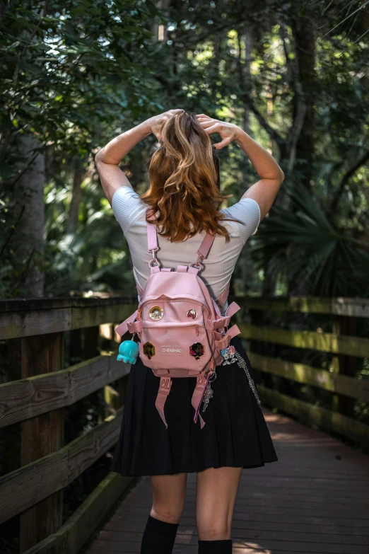 woman wearing a pink school bag on wooden walkway