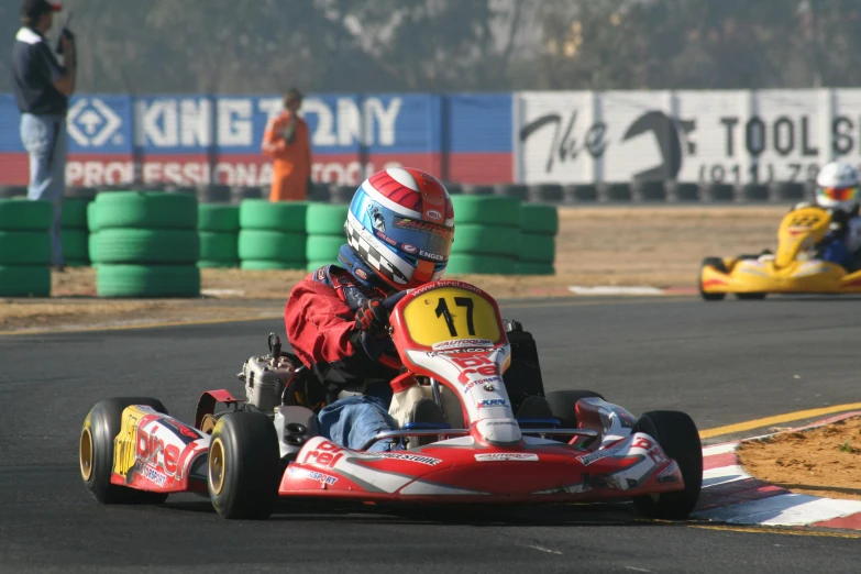 a boy driving a go kart with another one behind him