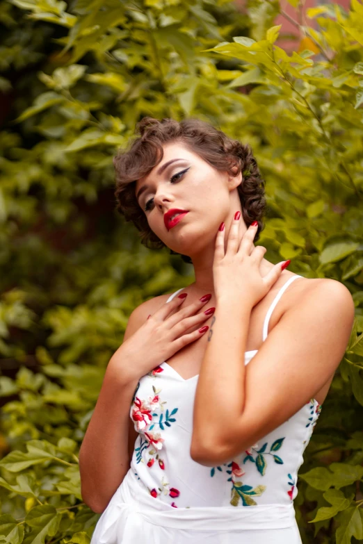 a woman in red nails holding her chest and making a face