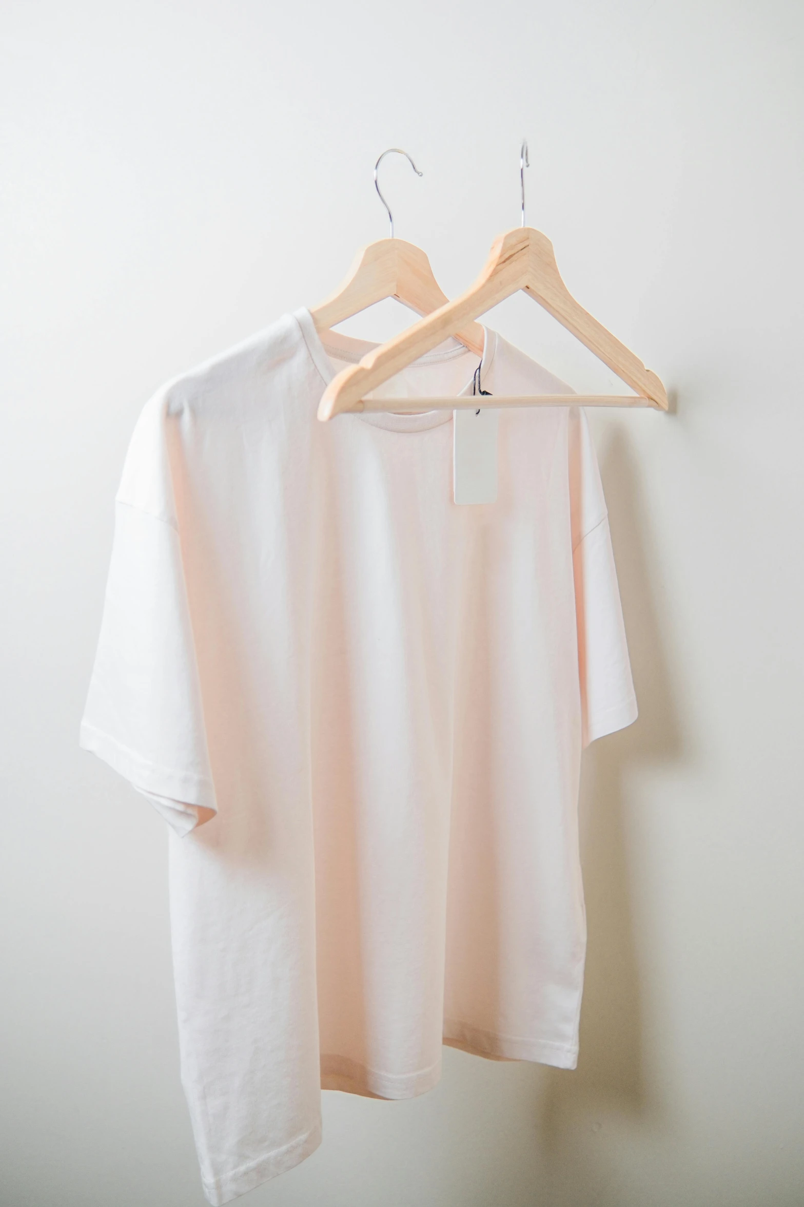 two shirts on a hanger and a t - shirt hanging
