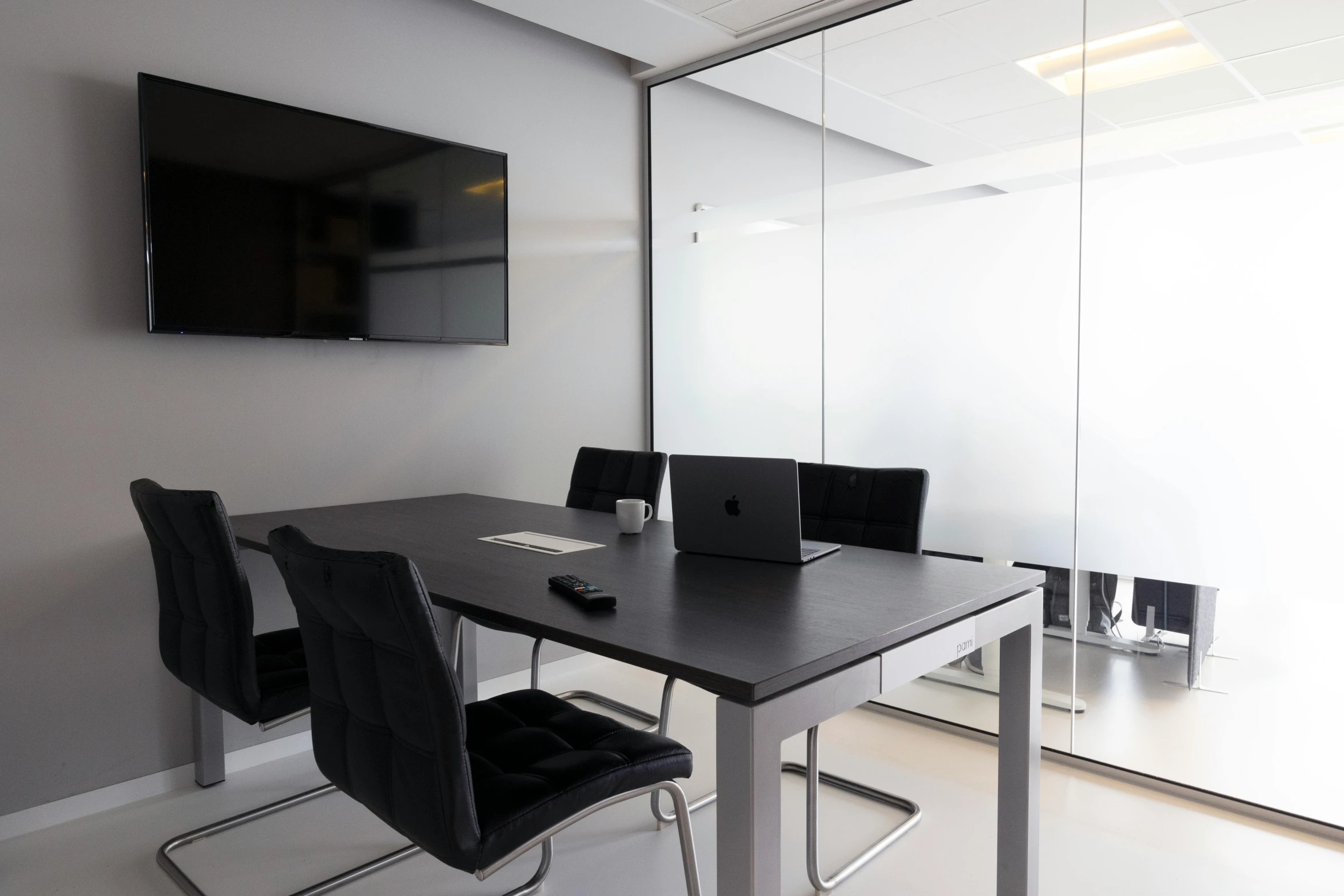 a table with black chairs in an empty office