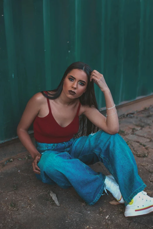 a woman posing for a po sitting against a wall