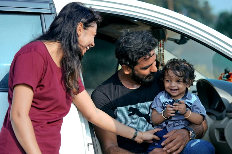 family on the steps of their van, looking around