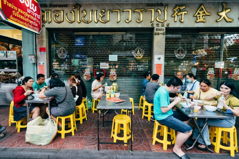 many people sitting at outdoor tables and talking